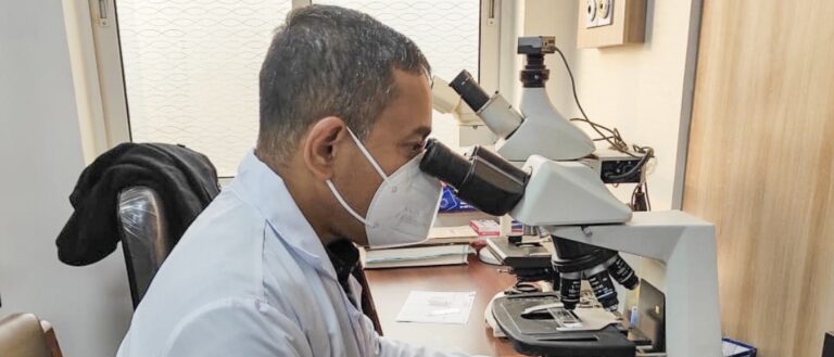 dr ram looks in microscope